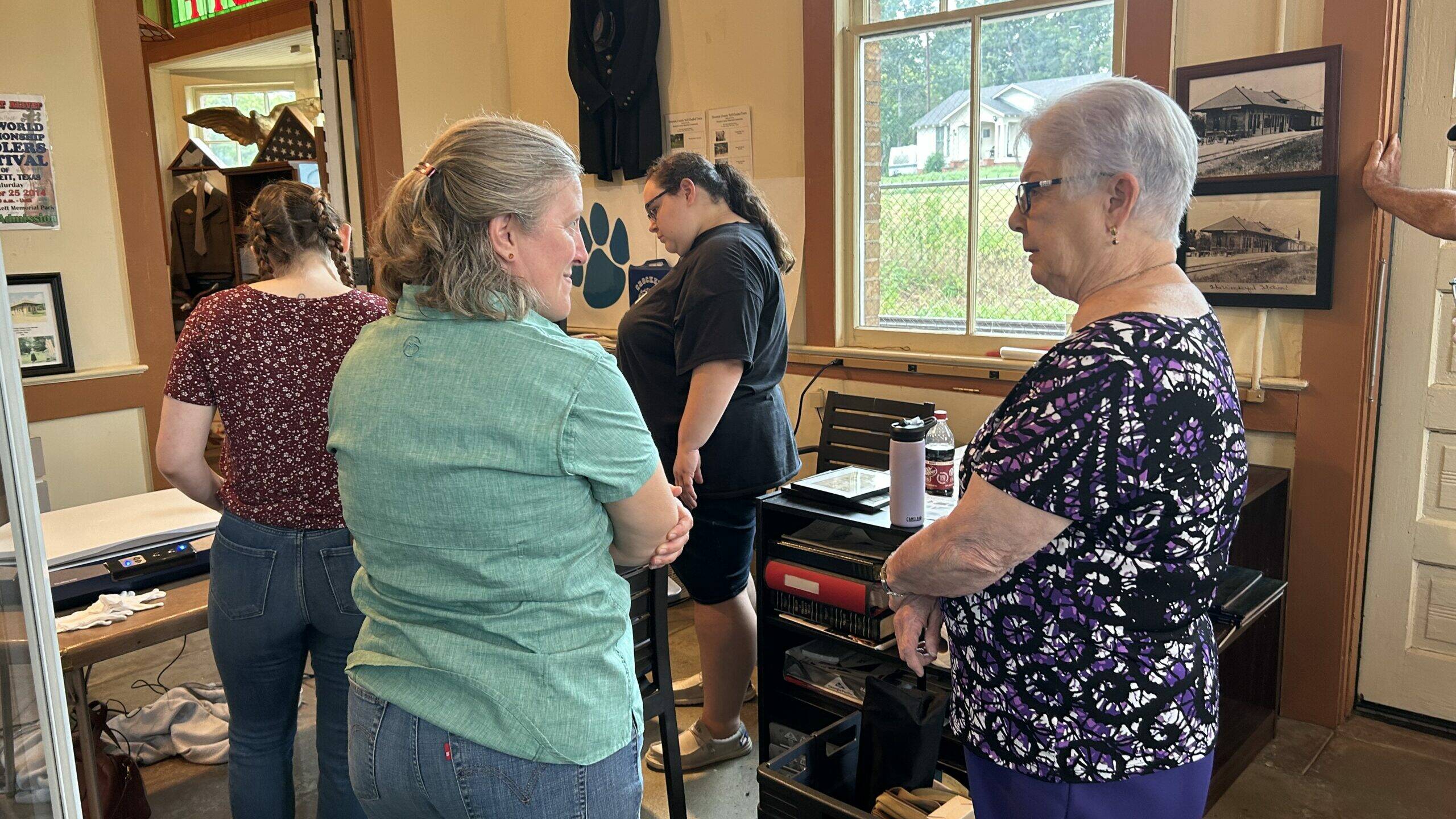 Perky Beisel and Museum Director Dorothy Parker talk while students from Stephen F. Austin digitize items from the museum